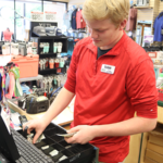 teen counting change at cash register