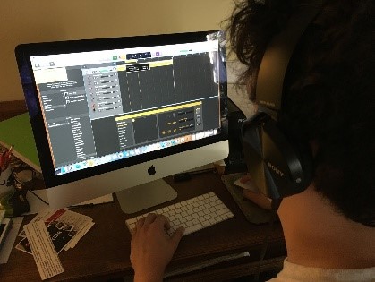 Teen using GarageBand on a computer to record music